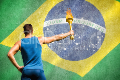 Composite image of rear view of athletic man holding the olympic