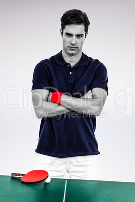 Composite image of portrait of male athlete standing with arms c