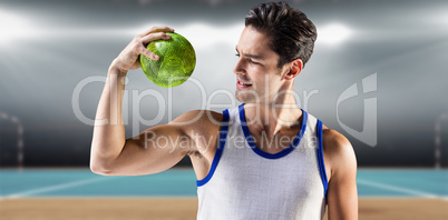 Composite image of happy male athlete holding a ball