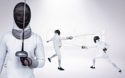 Composite image of man wearing fencing suit practicing with swor