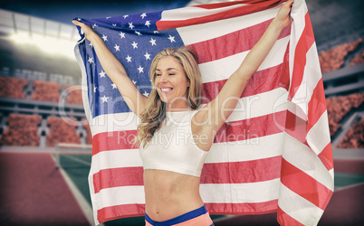 Composite image of athlete posing with american flag after victo