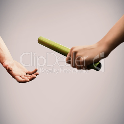 Composite image of athlete passing a baton to the partner