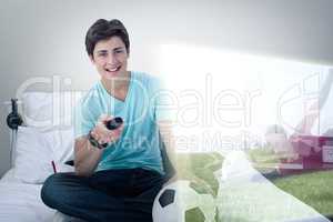 Composite image of young man is watching soccer match on televis