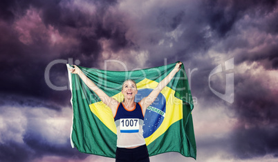 Composite image of athlete posing with brazilian flag after vict