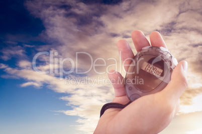 Close up of coach is holding a stopwatch  against cloudy sky ove