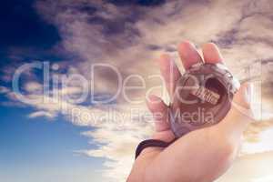 Close up of coach is holding a stopwatch  against cloudy sky ove