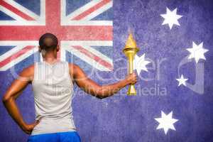 Composite image of rear view of sportsman holding a cup