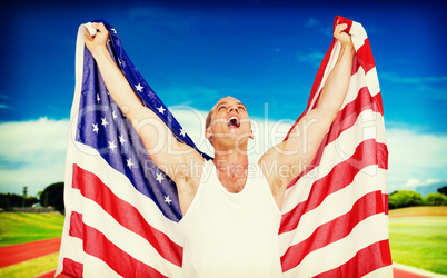 Composite image of athlete posing with american flag after victo