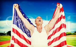 Composite image of athlete posing with american flag after victo