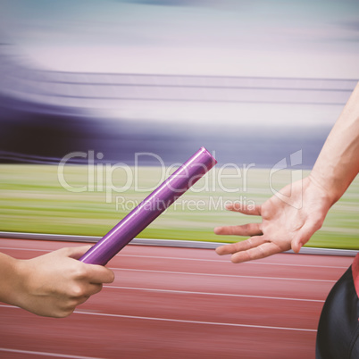 Athlete passing a baton to the partner