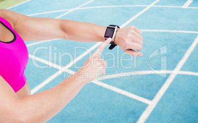 Composite image of female athlete using her smart watch