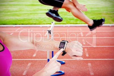 Composite image of female athlete using her smart watch