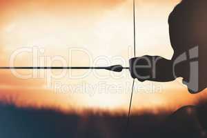 Composite image of close up of sportswoman practising archery on