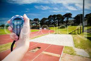 Composite image of a woman holding a chronometer to measure perf