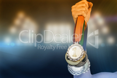 Composite image of athlete holding gold medals after victory