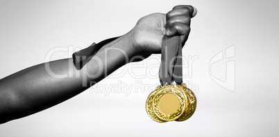 Hand holding three gold medals