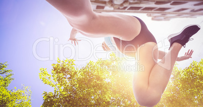 Composite image of low angle female athlete jumping