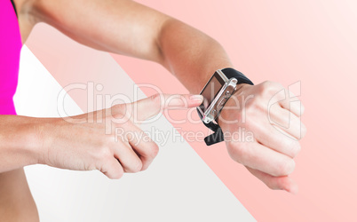 Composite image of female athlete using her smart watch