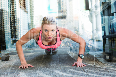Composite image of a pretty woman doing push-ups on the floor