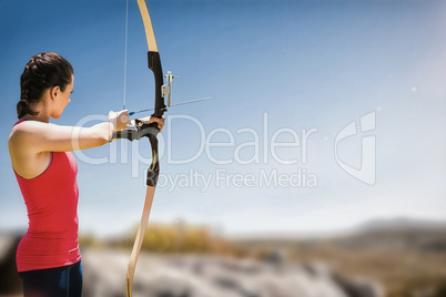 Composite image of side view of woman practicing archery