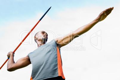 Composite image of low angle view of sportsman practising javeli