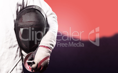 Composite image of mid-section of man standing with fencing mask