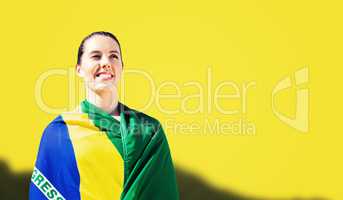 Composite image of sporty woman holding brazilian flag