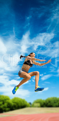Sporty woman jumping against athletics field