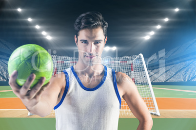 Composite image of portrait of happy male athlete holding a ball