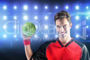 Composite image of portrait of happy athlete man holding a ball