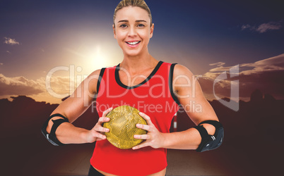 Composite image of female athlete with elbow pad holding handbal