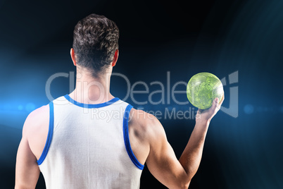 Composite image of rear view of male athlete holding ball