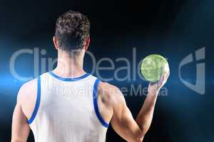 Composite image of rear view of male athlete holding ball