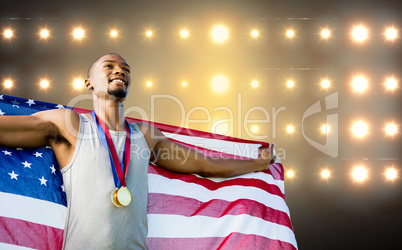 Portrait of happy sportsman posing with an american flag  agains