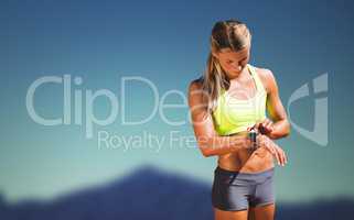 Composite image of sporty woman looking her watch