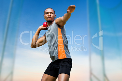 Composite image of front view of sportsman practising shot put