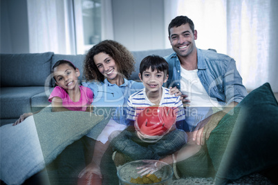 Composite image of family is watching sport on television