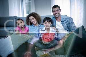 Composite image of family is watching sport on television