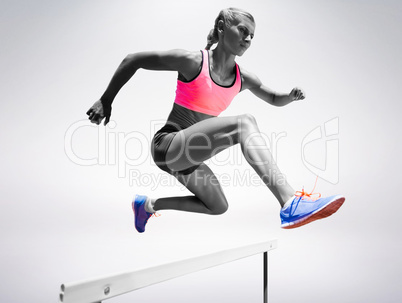 Sporty woman jumping a hurdle