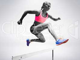 Sporty woman jumping a hurdle