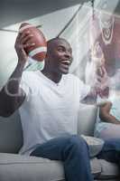 Composite image of happy man is watching sport on television