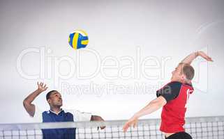 Composite image of sportsman hitting volleyball