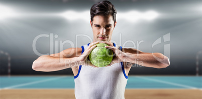 Composite image of portrait of happy athlete man holding ball
