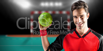 Composite image of portrait of happy athlete man holding a ball