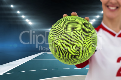 Composite image of sportswoman holding a ball