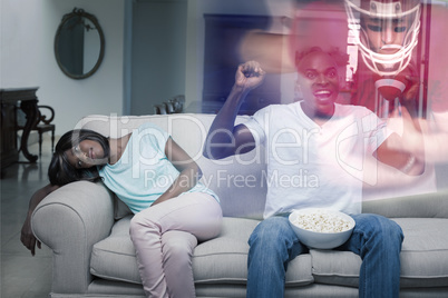 Composite image of man watching sport on television next to his
