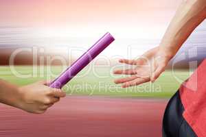 Composite image of athlete passing a baton to the partner