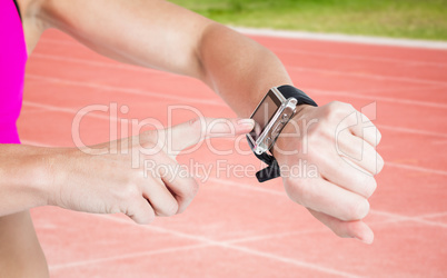 Composite image of female athlete using her smart watch