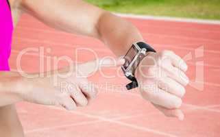 Composite image of female athlete using her smart watch