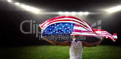 Composite image of rear view of sportsman holding american flag